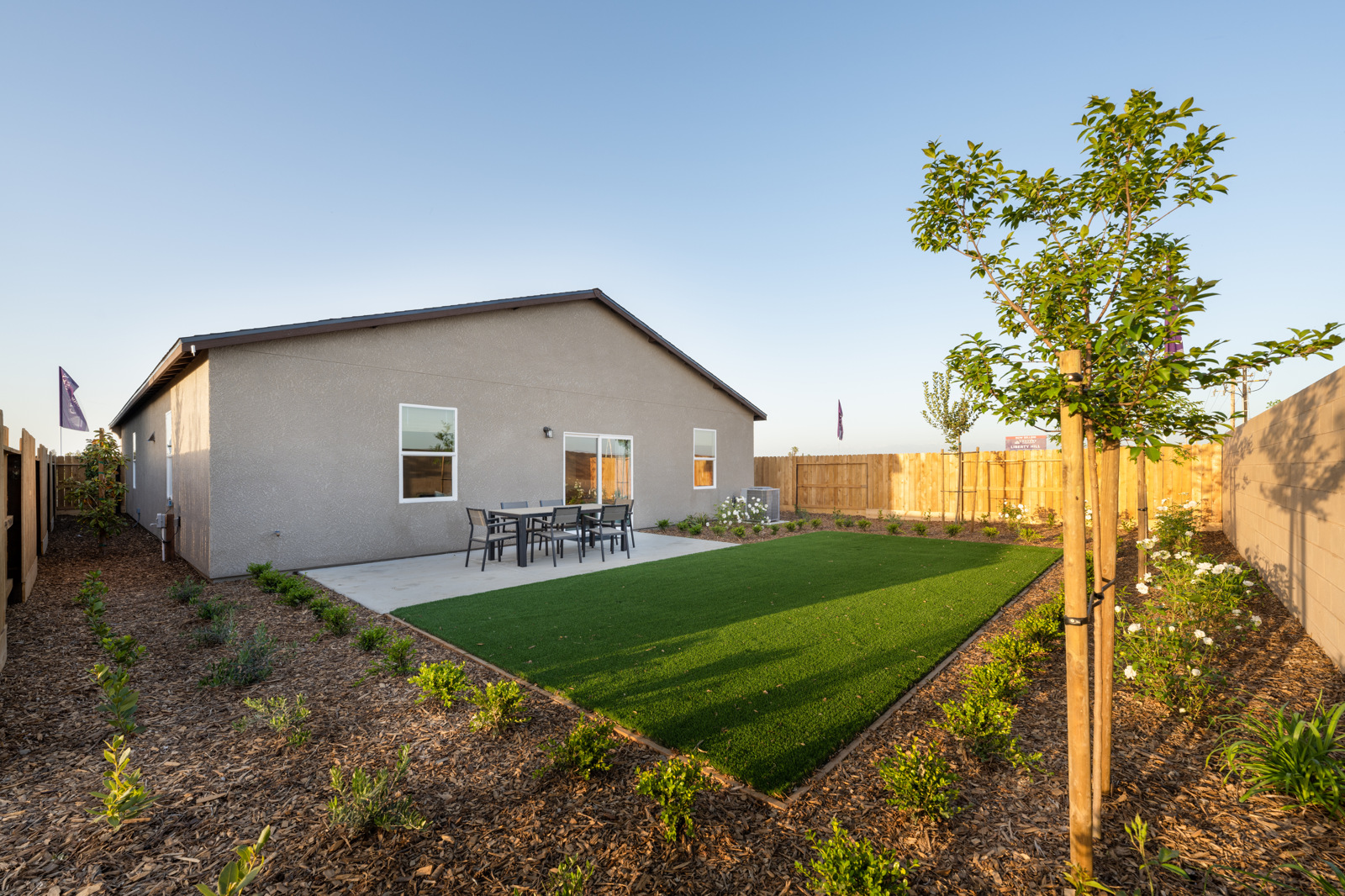 A backyard with a fence and a house.