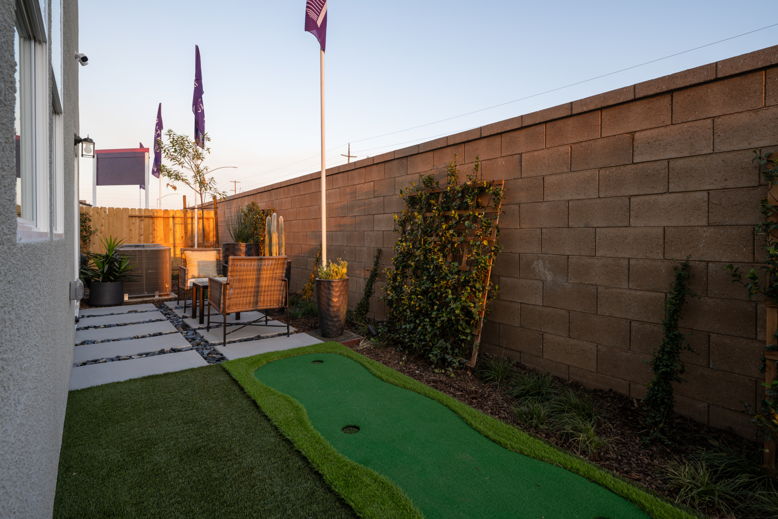 A backyard with a pool and a brick wall.