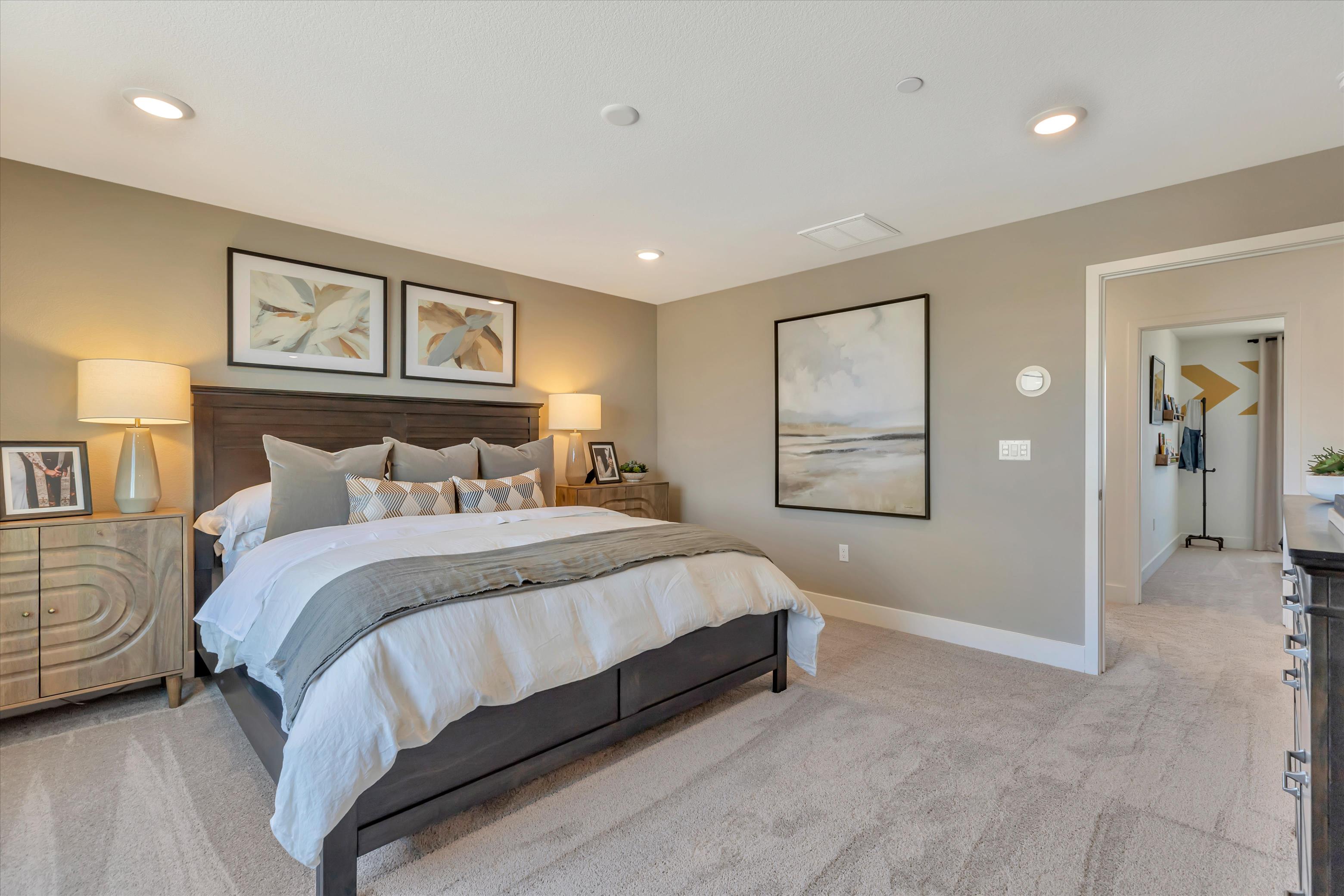 A bedroom with a bed and lamps.