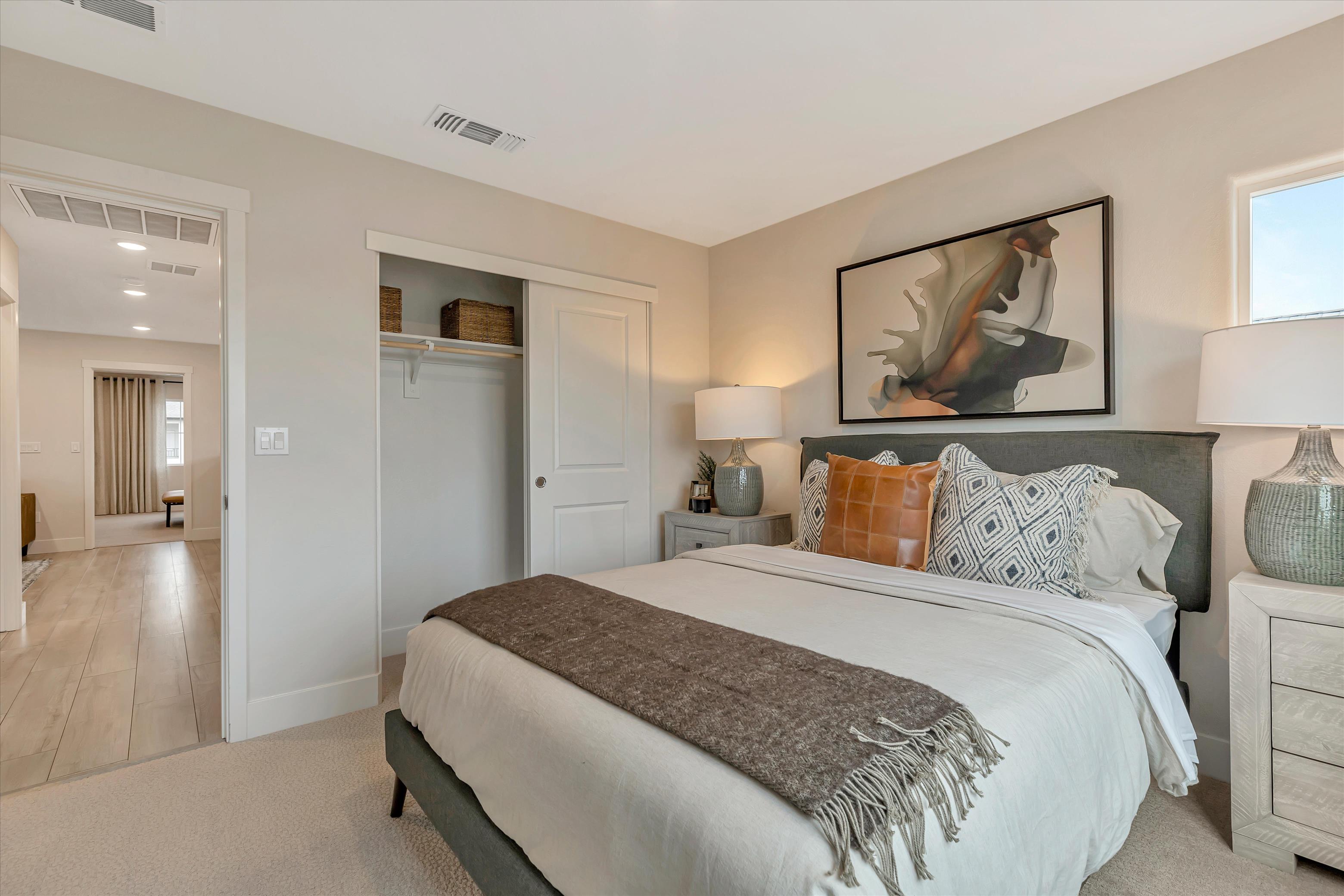 A bedroom with a bed and a lamp.