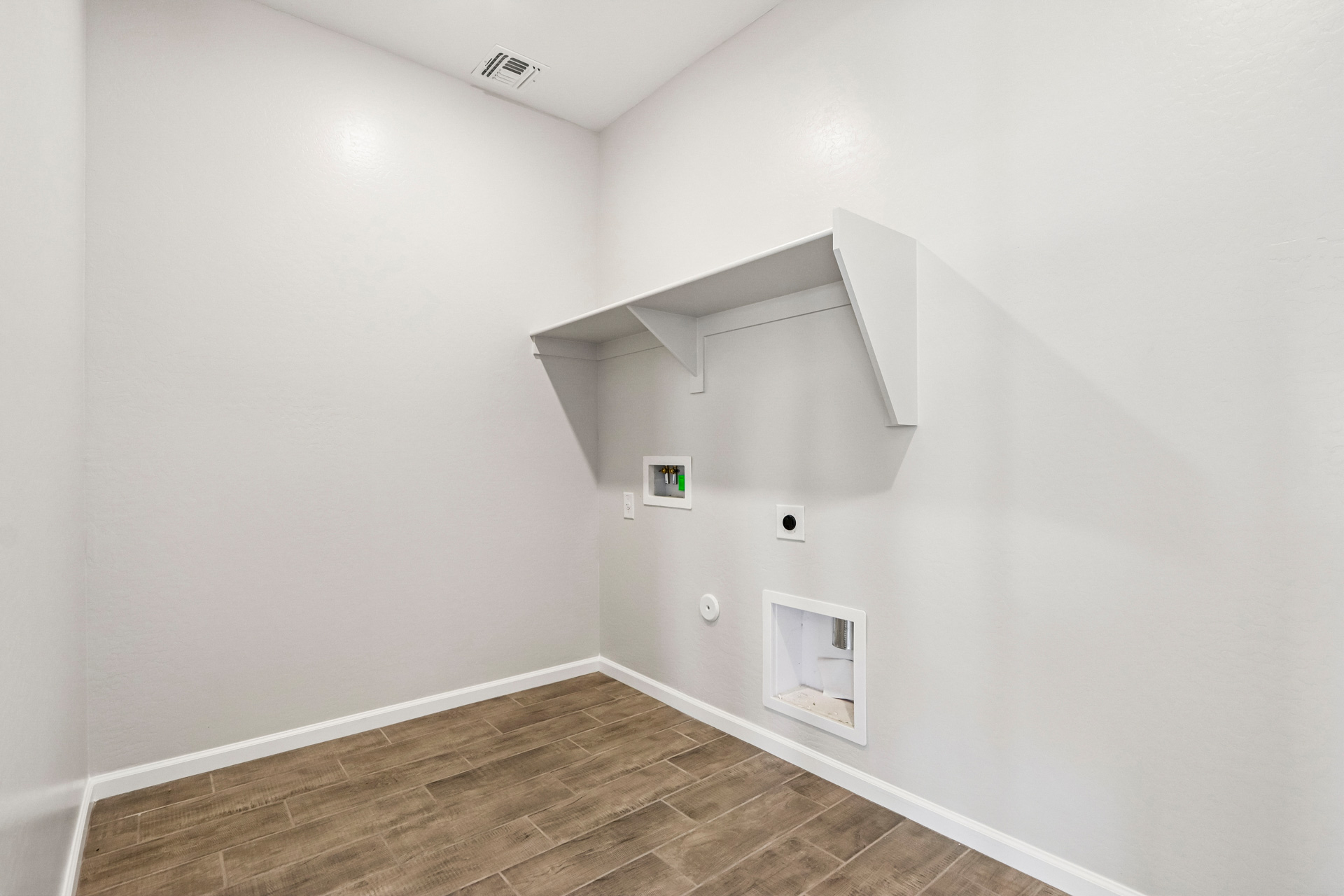 A white room with a wood floor.