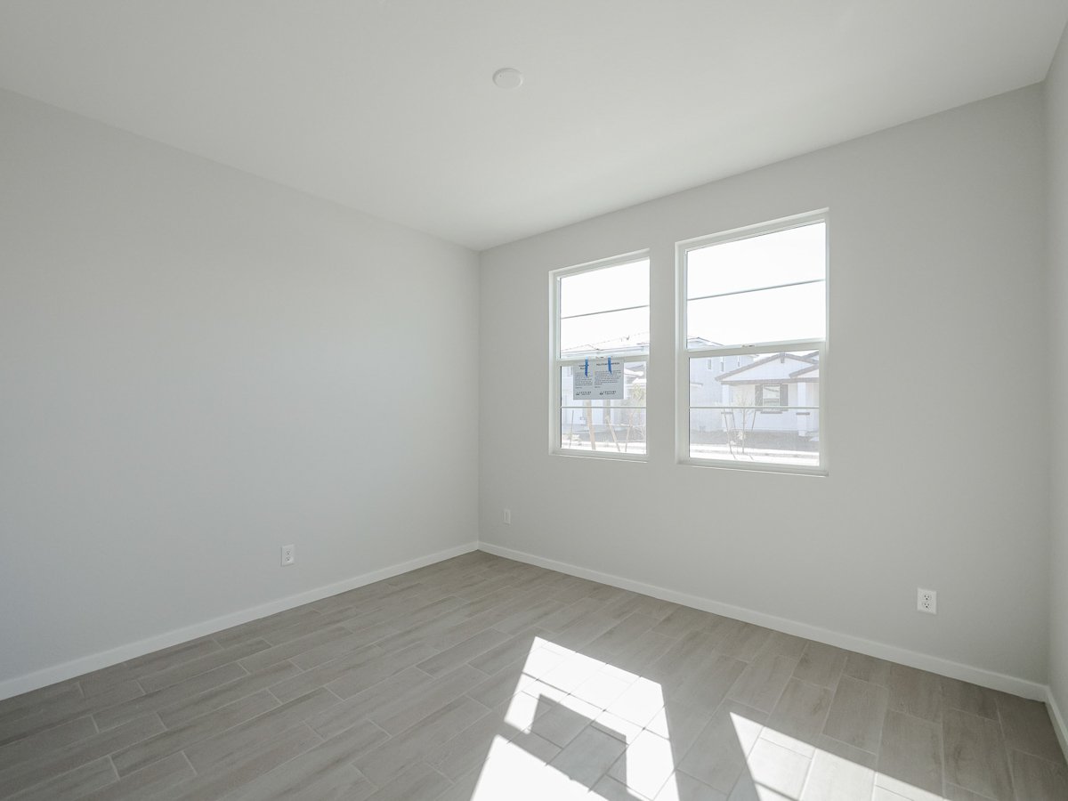 A room with a window and a wood floor.