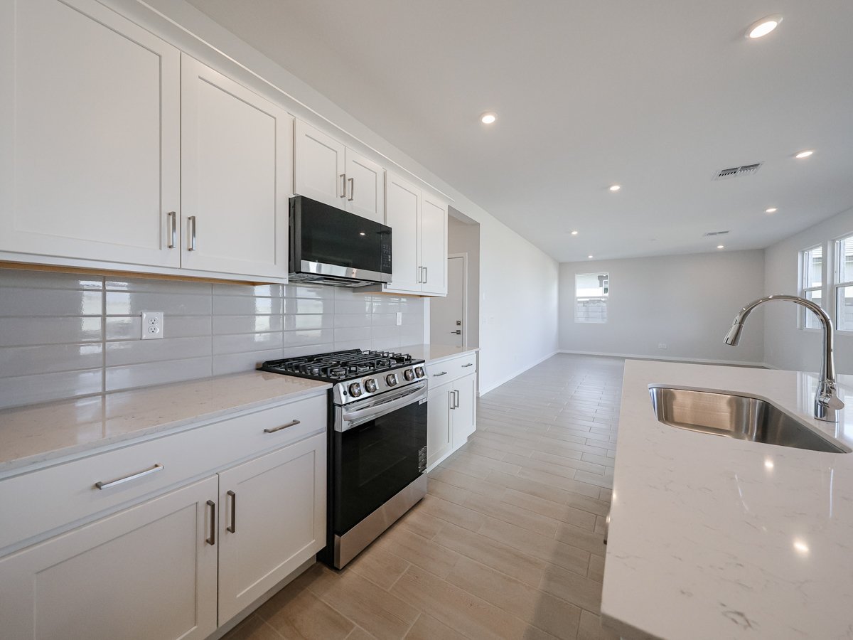 A kitchen with white cabinets.