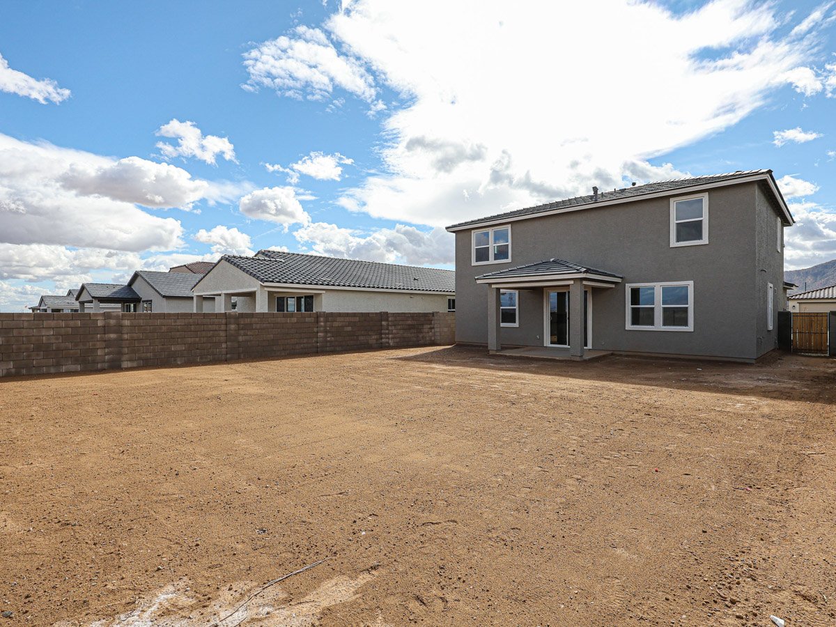 A dirt road leading to a house.