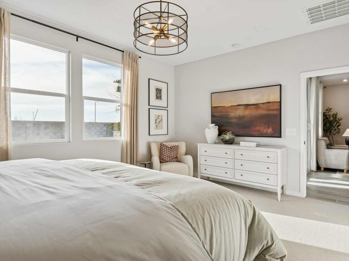 A bedroom with a bed and a chair.