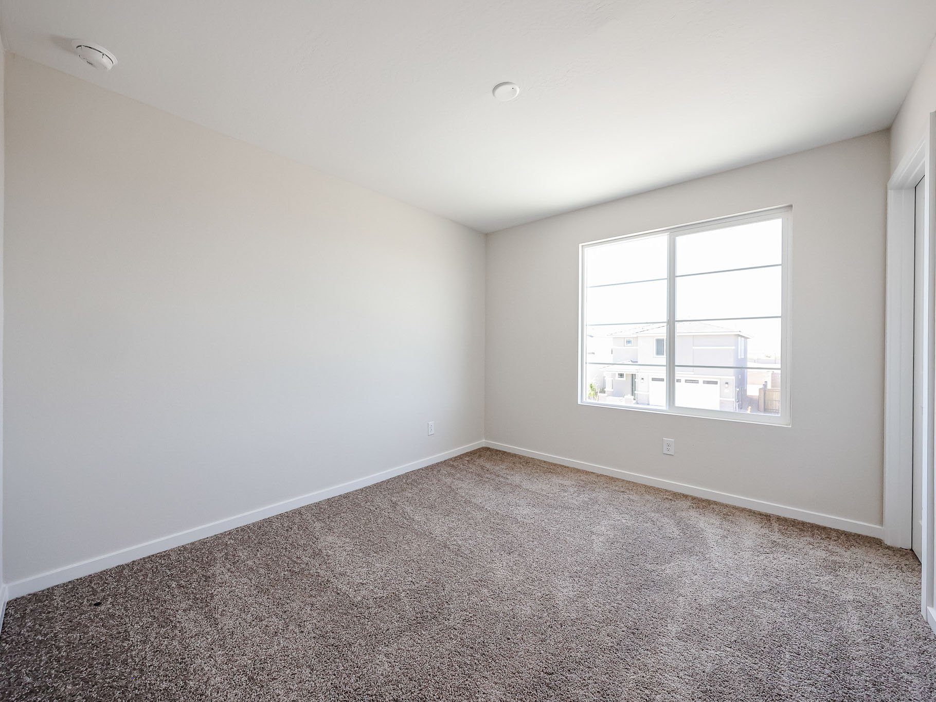 A room with a window and carpet.