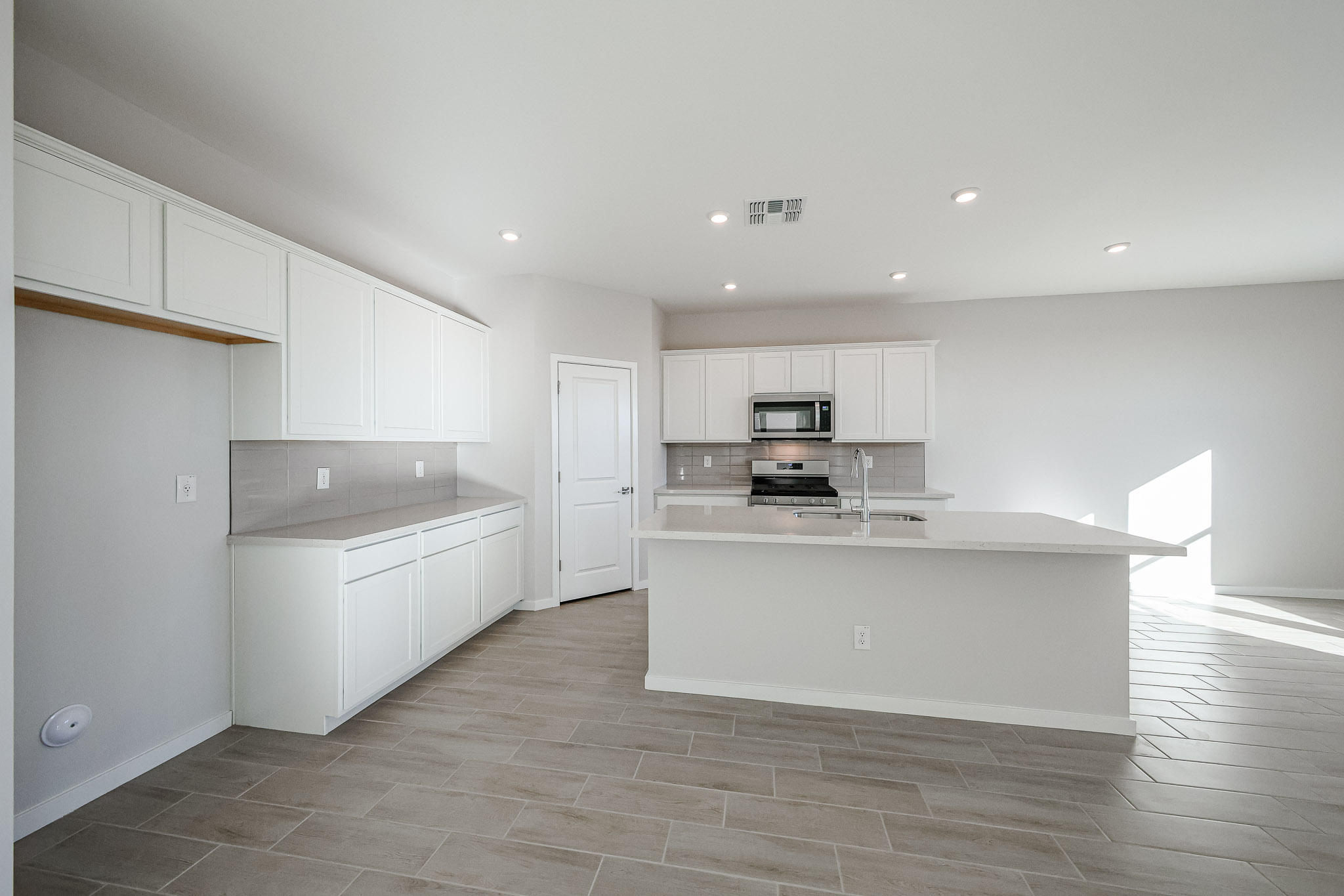 A kitchen with white cabinets.