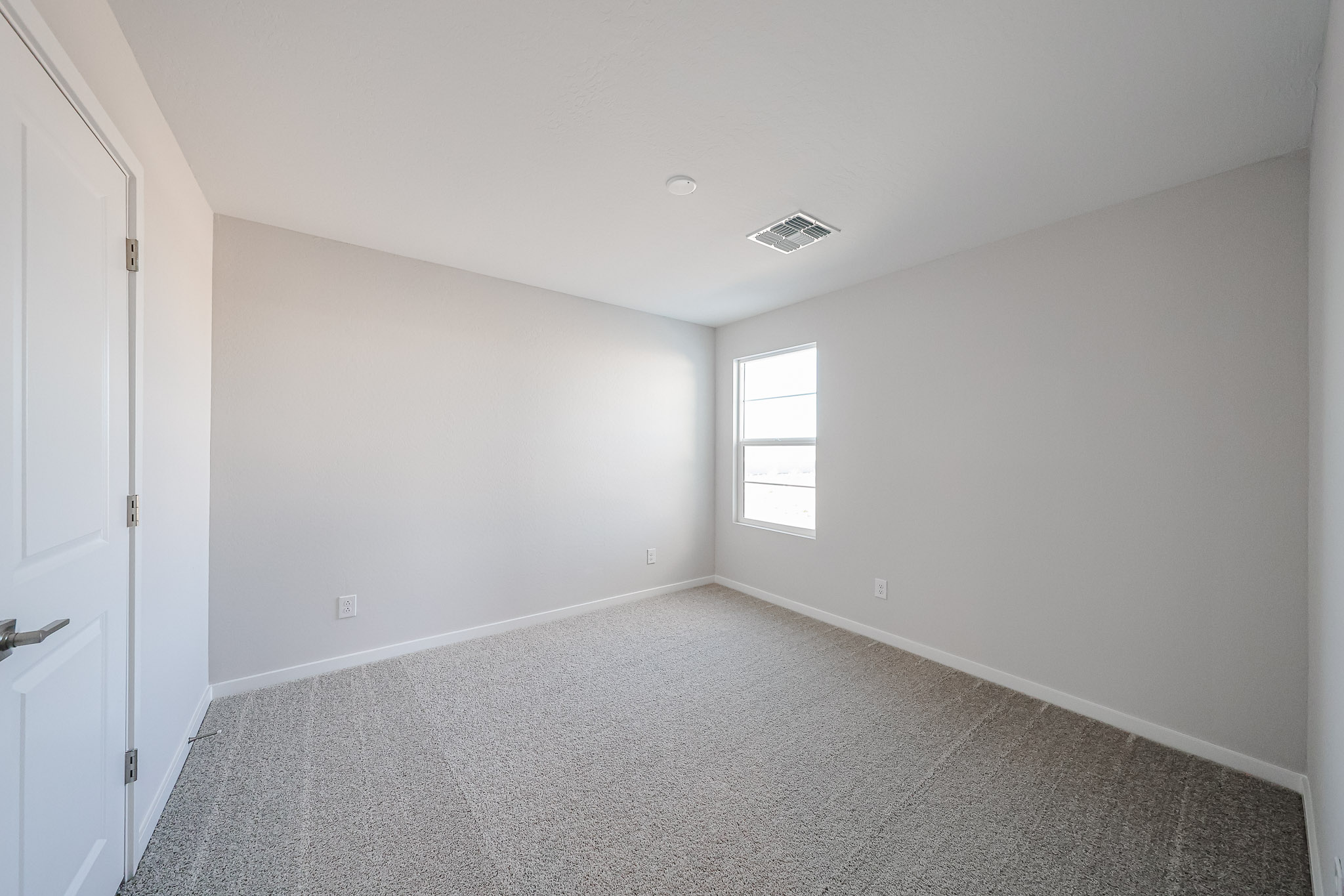 A room with a carpet and a window.