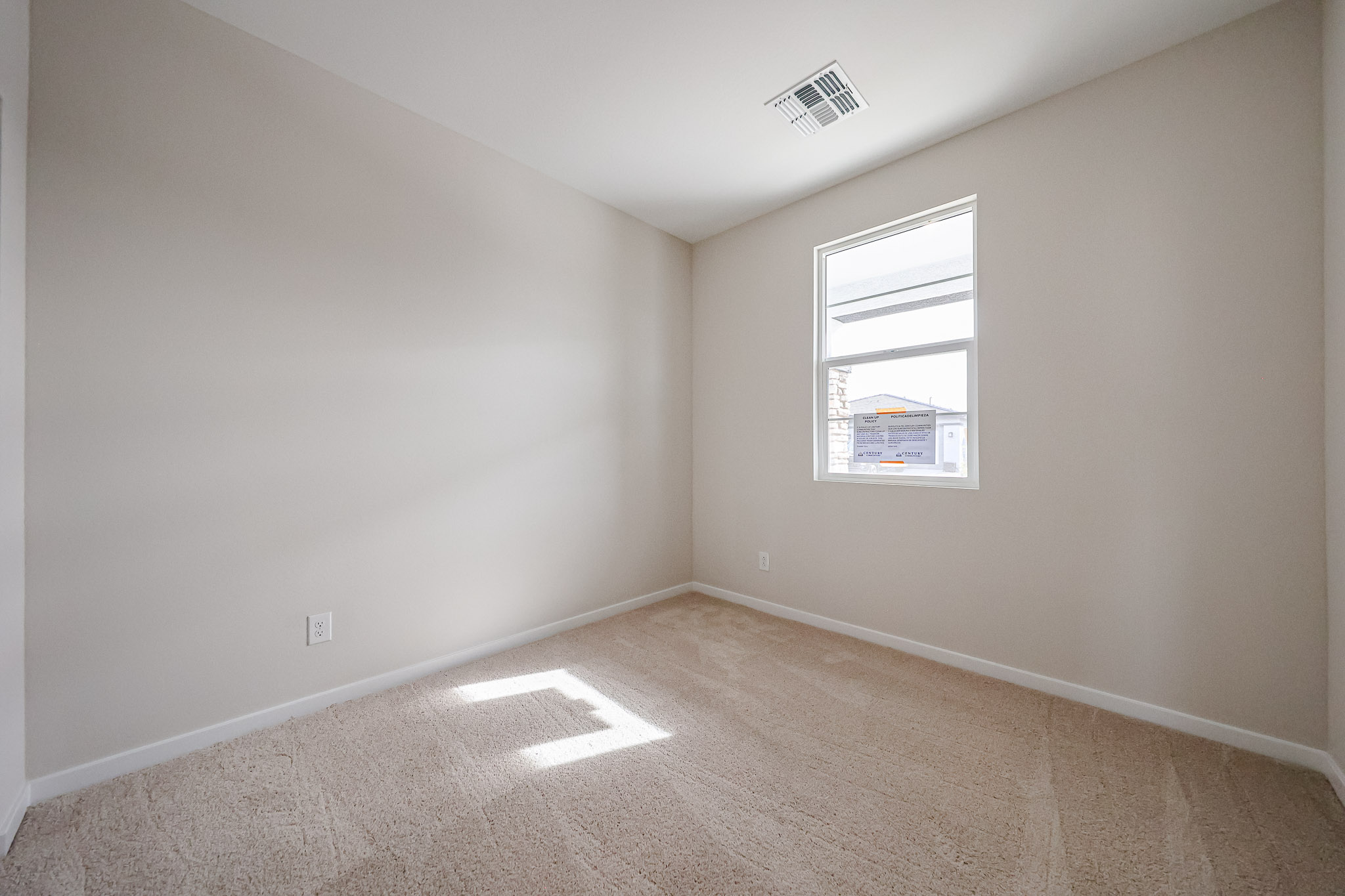 A room with a carpet and a sign on the wall.