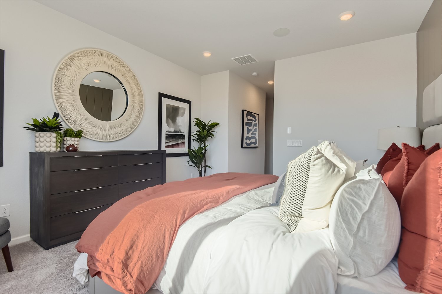 A bedroom with a bed and a mirror.