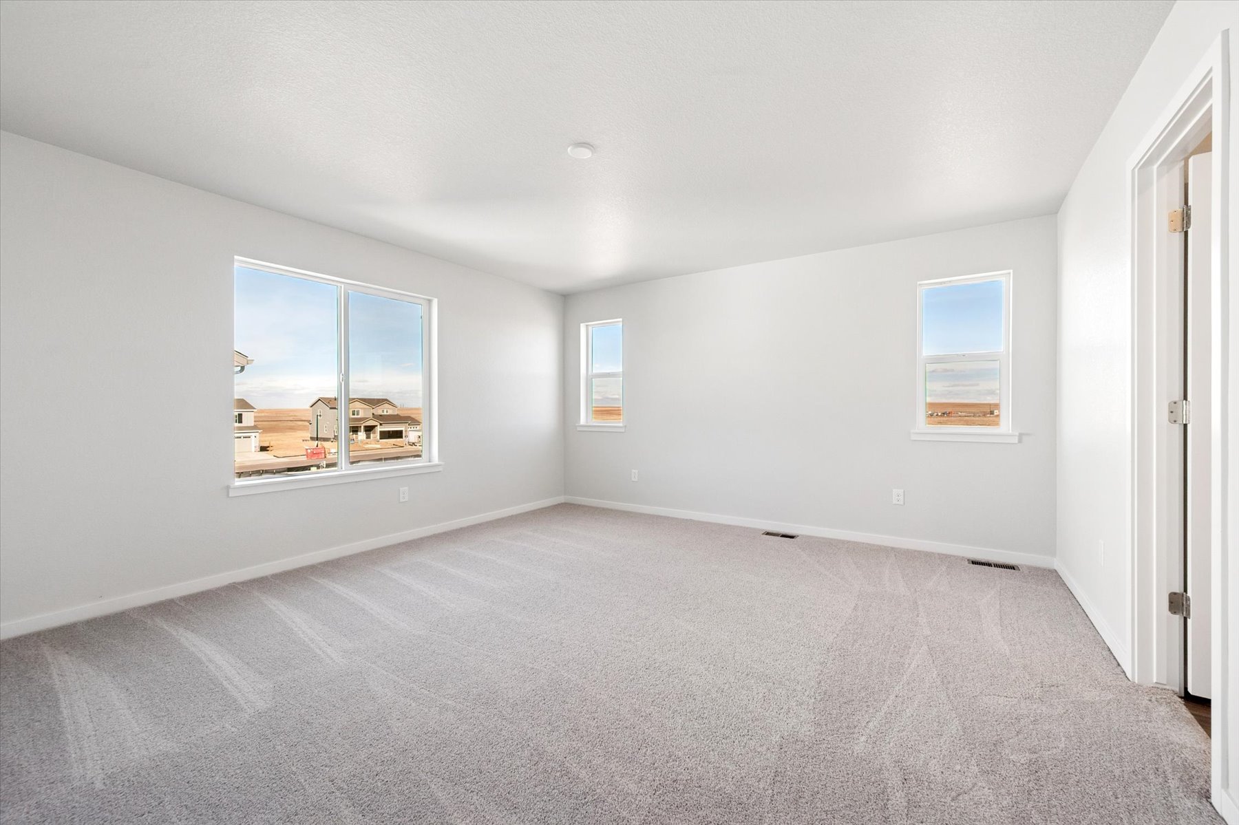 A room with a window and a carpet.