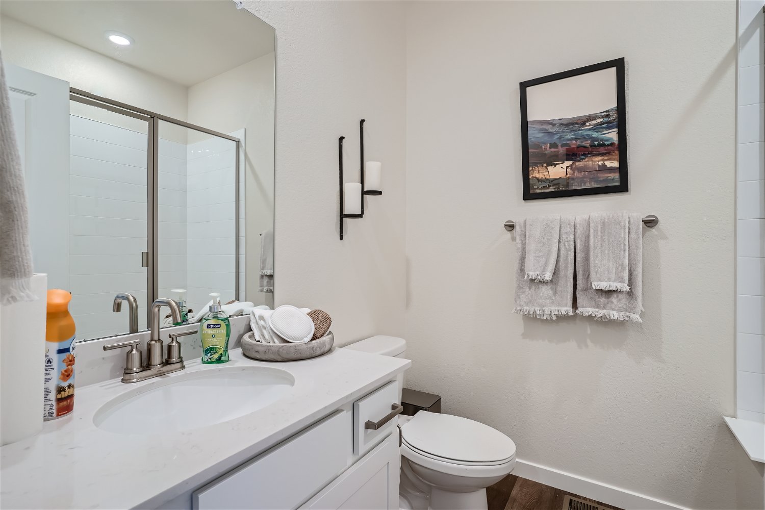 A bathroom with a sink toilet and towels.