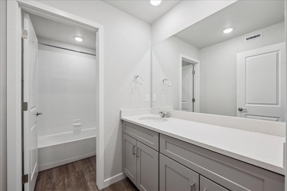A bathroom with a tub sink and shower.