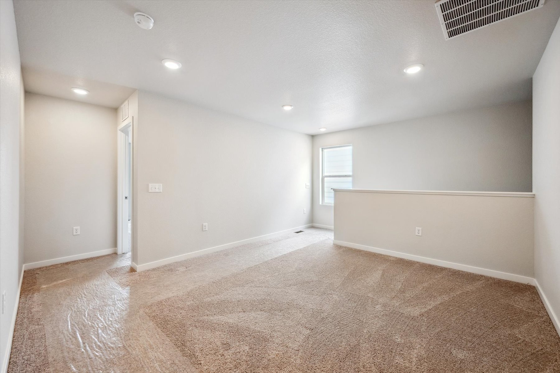 A room with a carpet and a door.