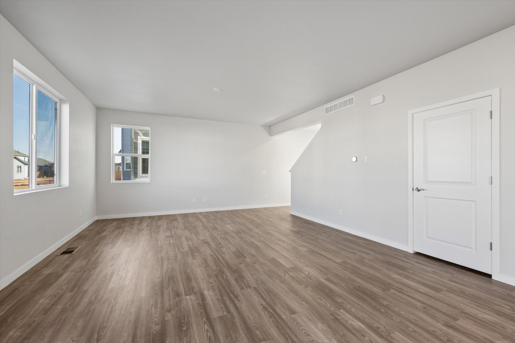 A room with white walls and a wood floor.