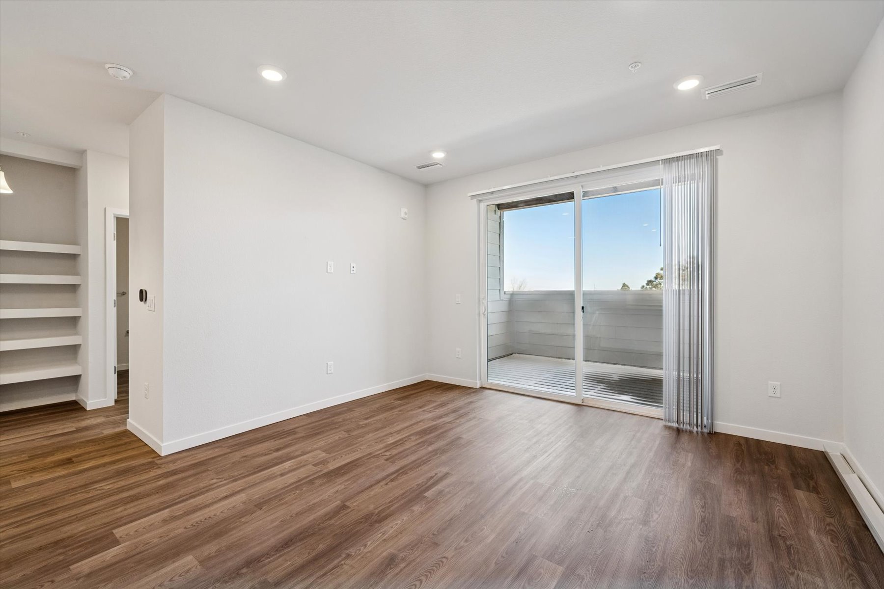 A room with a wood floor and a glass door.