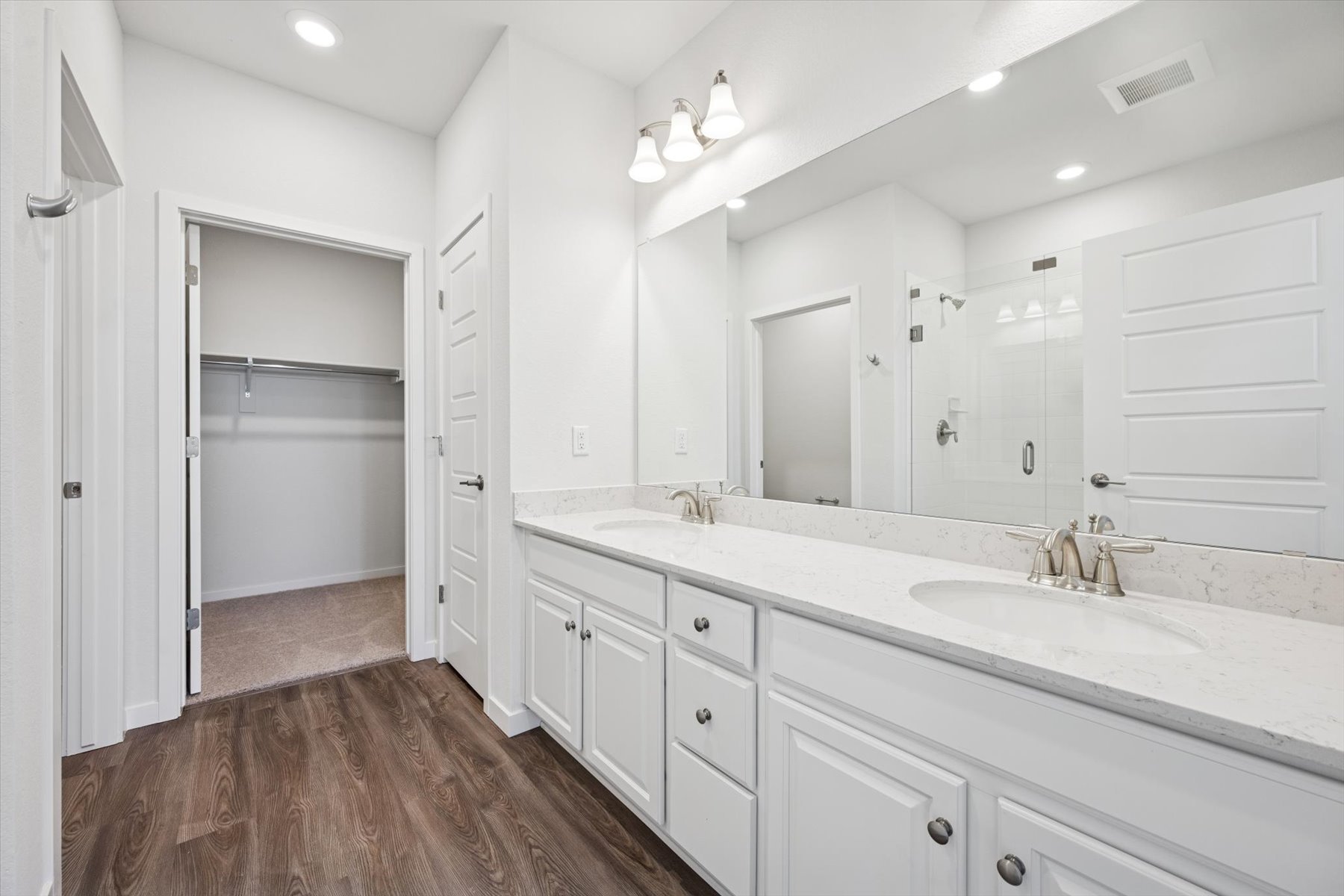 A bathroom with white cabinets.