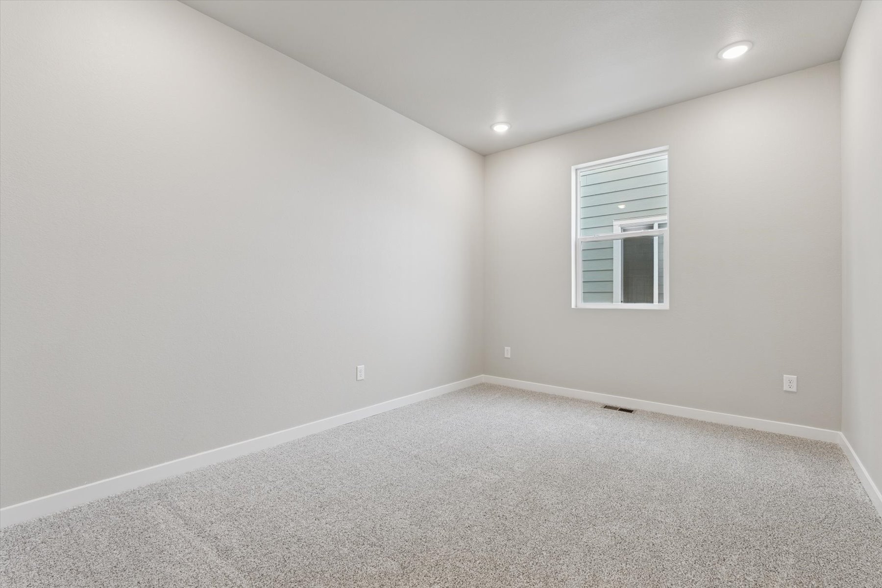 A room with a window and a carpet.