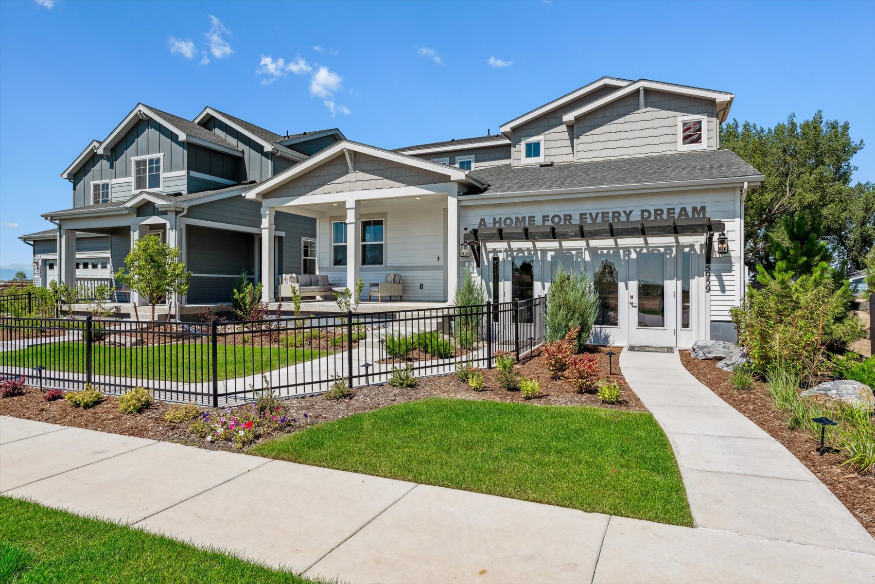 A house with a fence and a lawn in front of it.