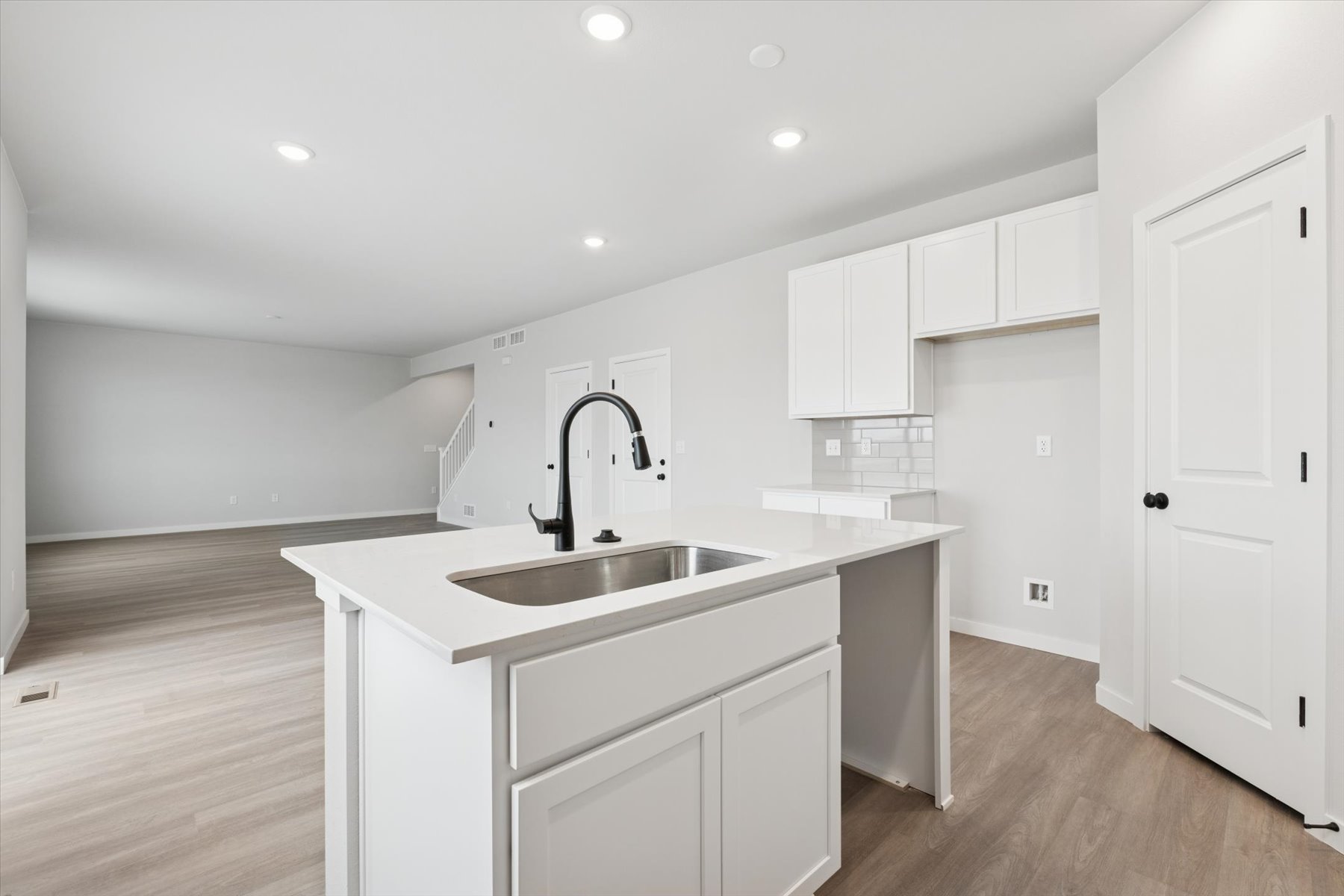 A kitchen with white cabinets.