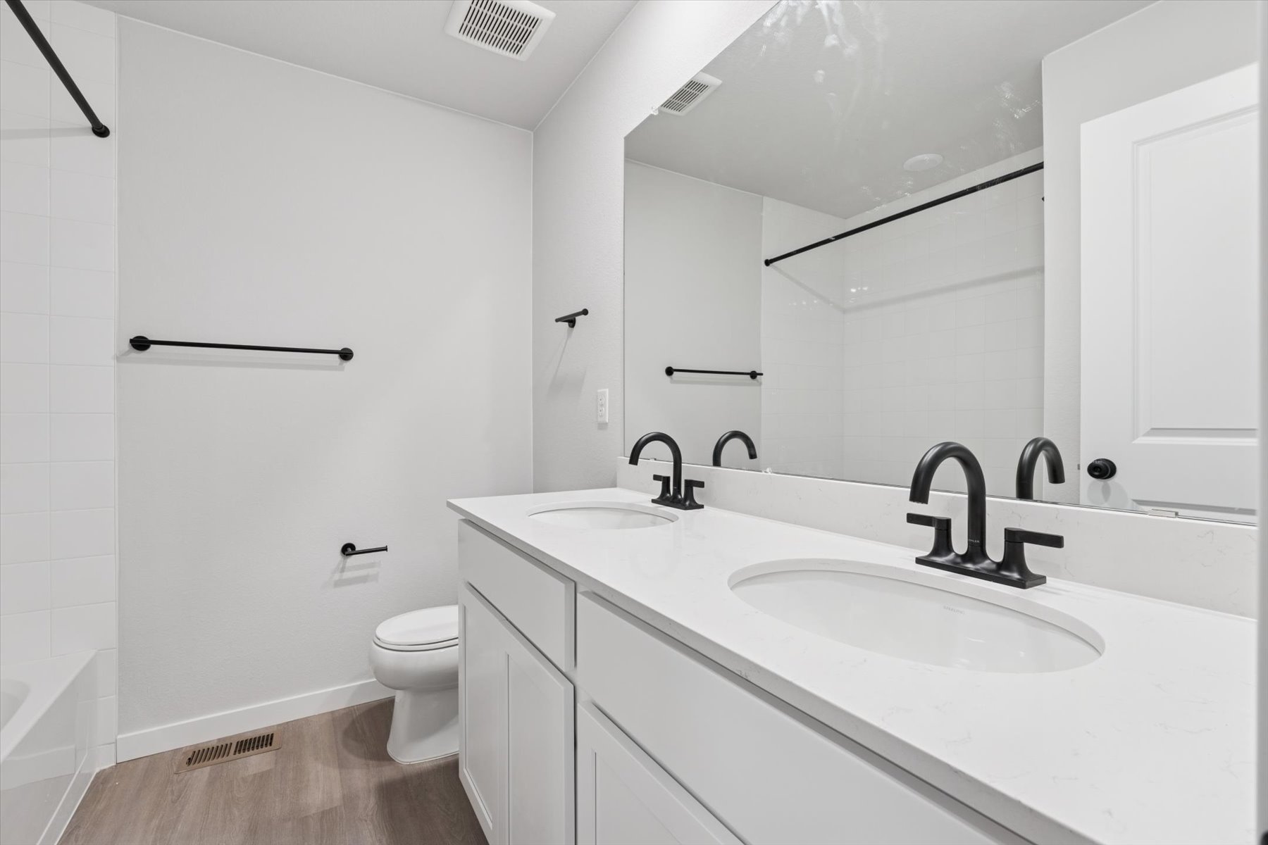 A bathroom with a sink toilet and mirror.