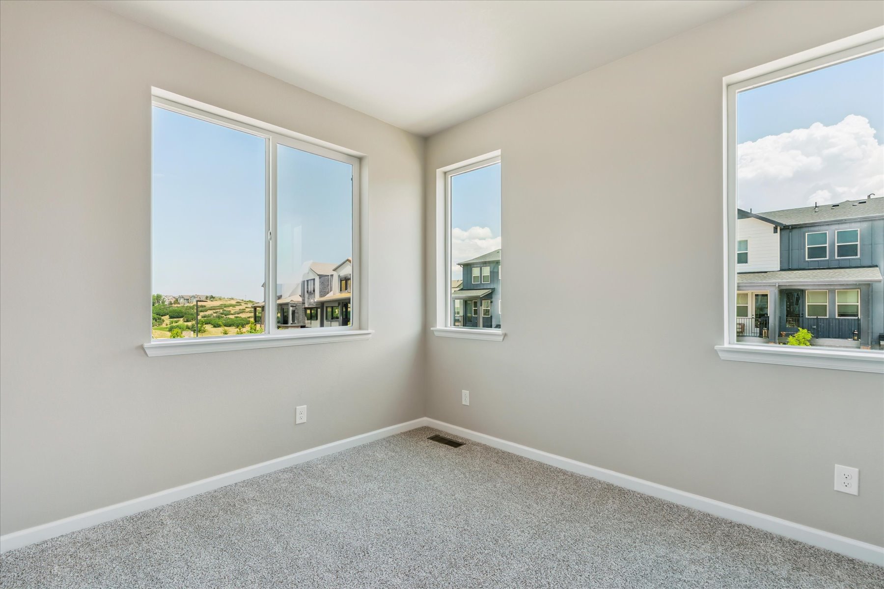 A room with windows and a carpet.