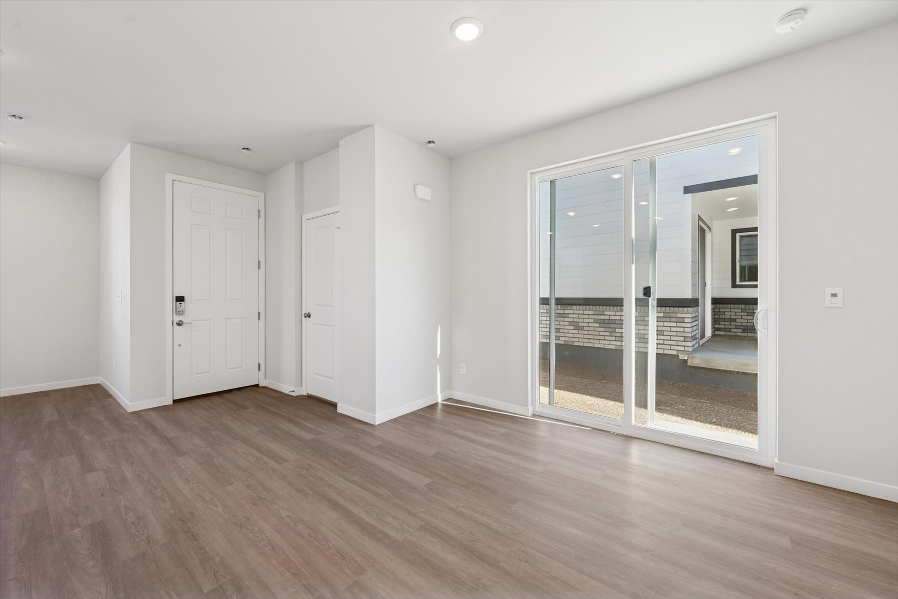 A room with white walls and a glass door.