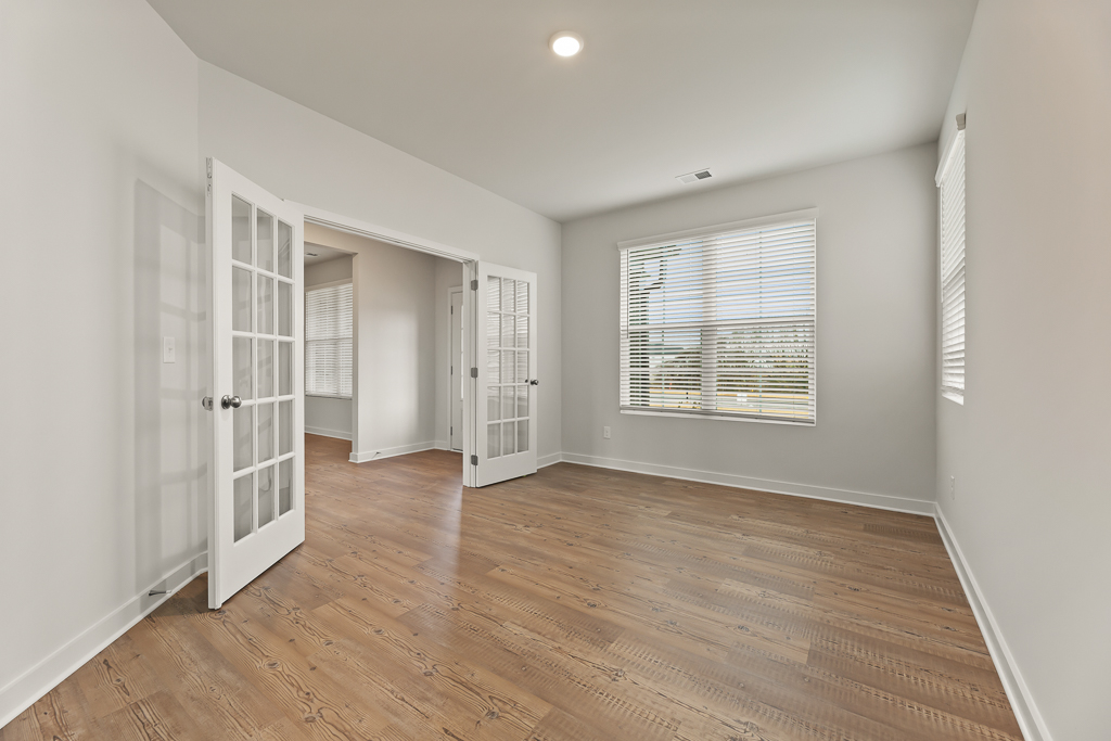 A room with white walls and wood floors.