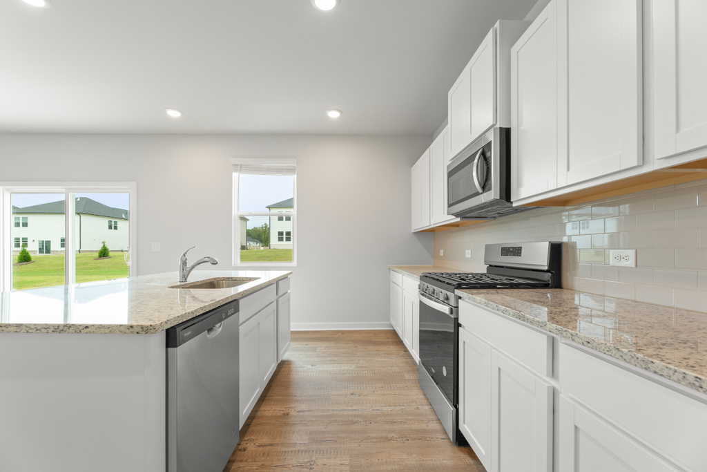 A kitchen with white cabinets.