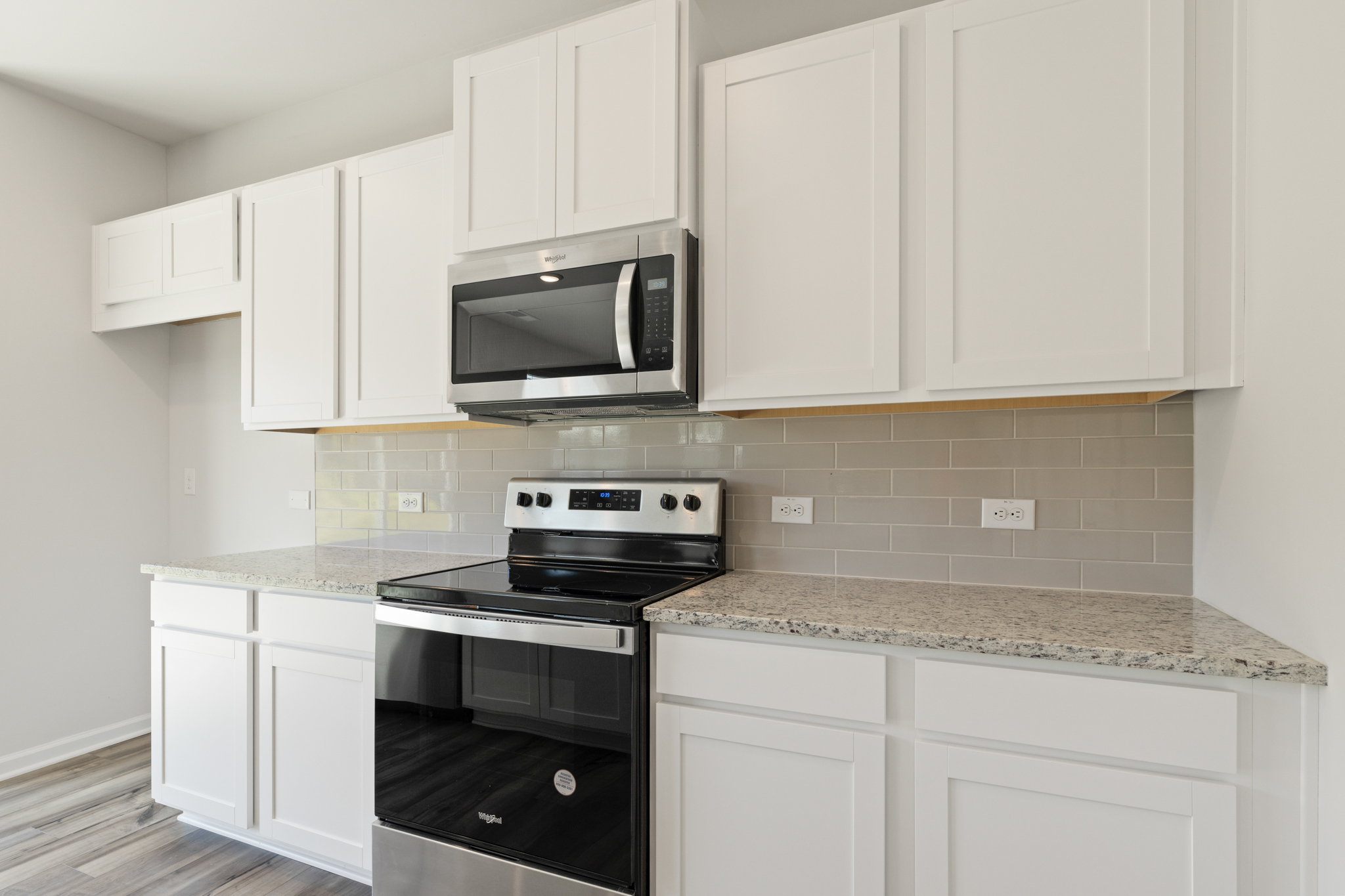 A kitchen with white cabinets.