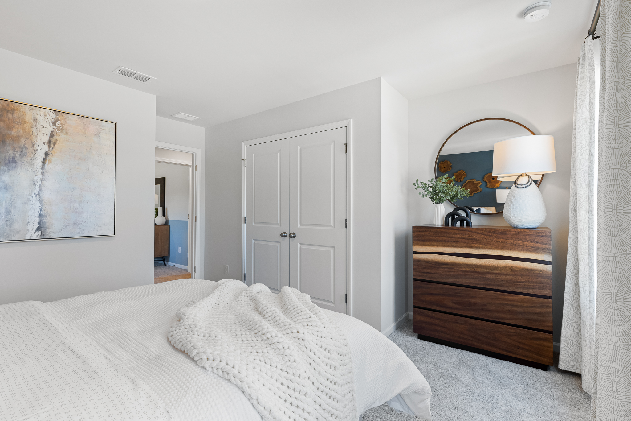 A bedroom with a bed and a lamp.