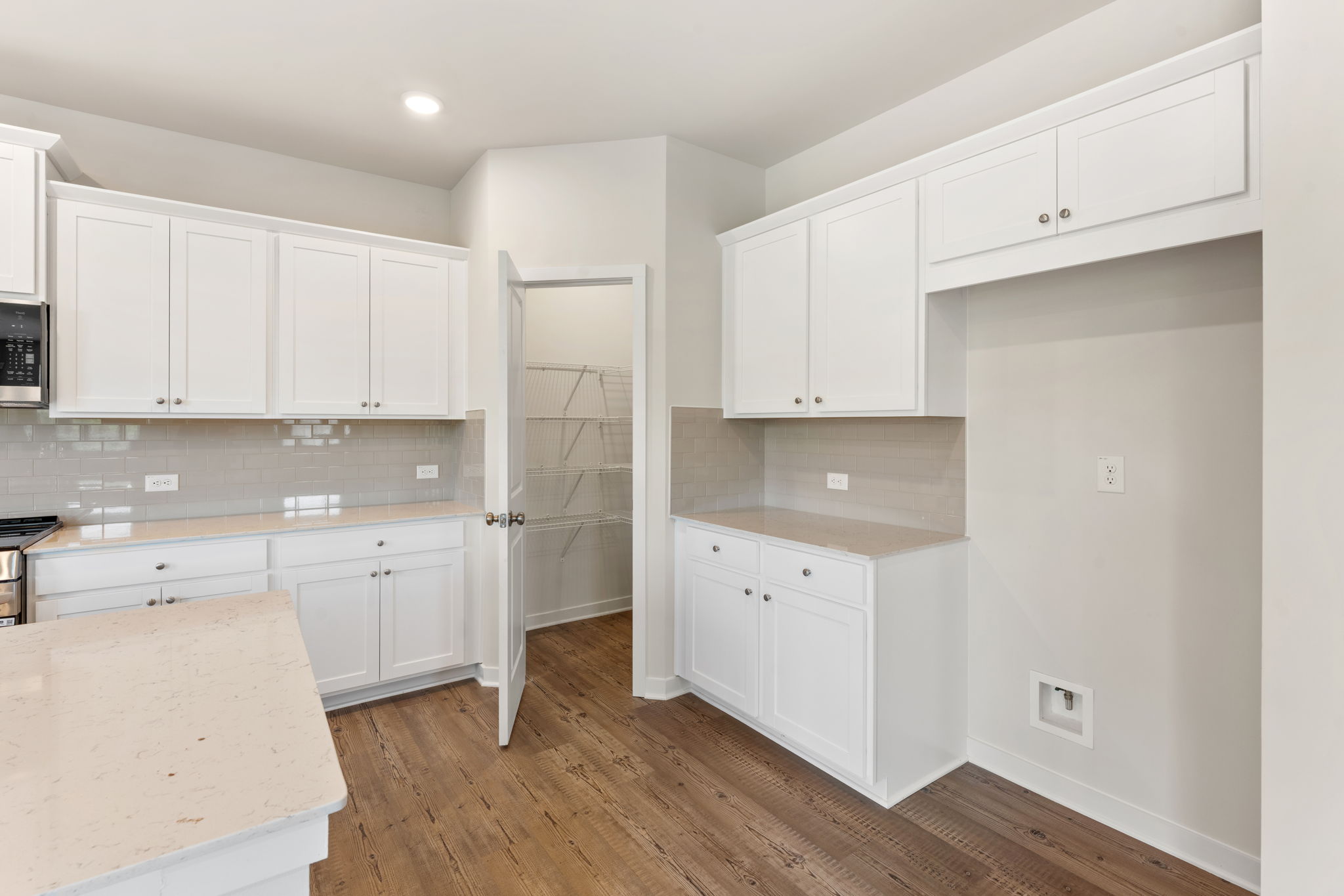 A kitchen with white cabinets.