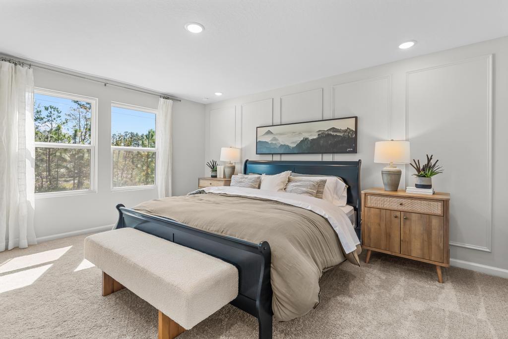 A bedroom with a bed and a bench.