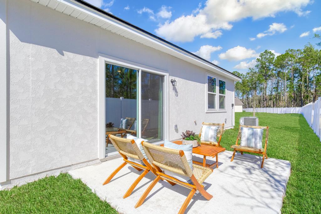 A patio with chairs and a table.