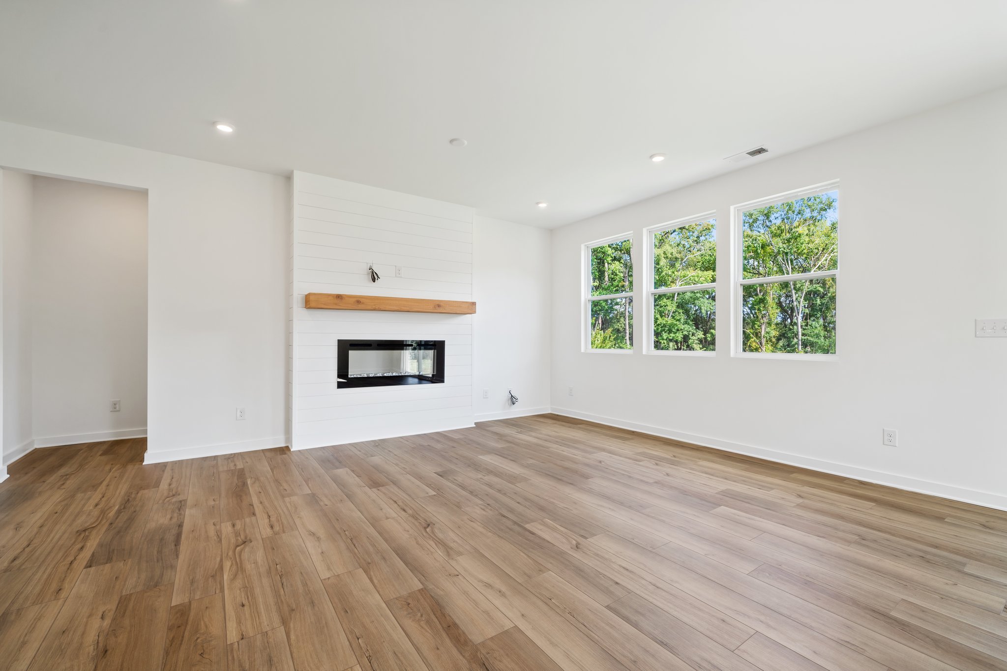A room with a fireplace and a wood floor.