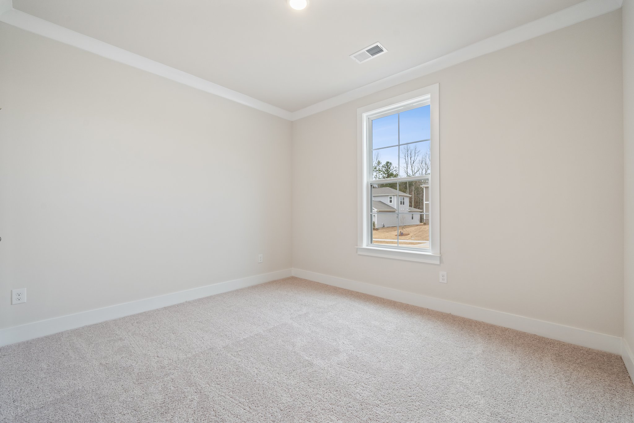 A room with a window and carpet.