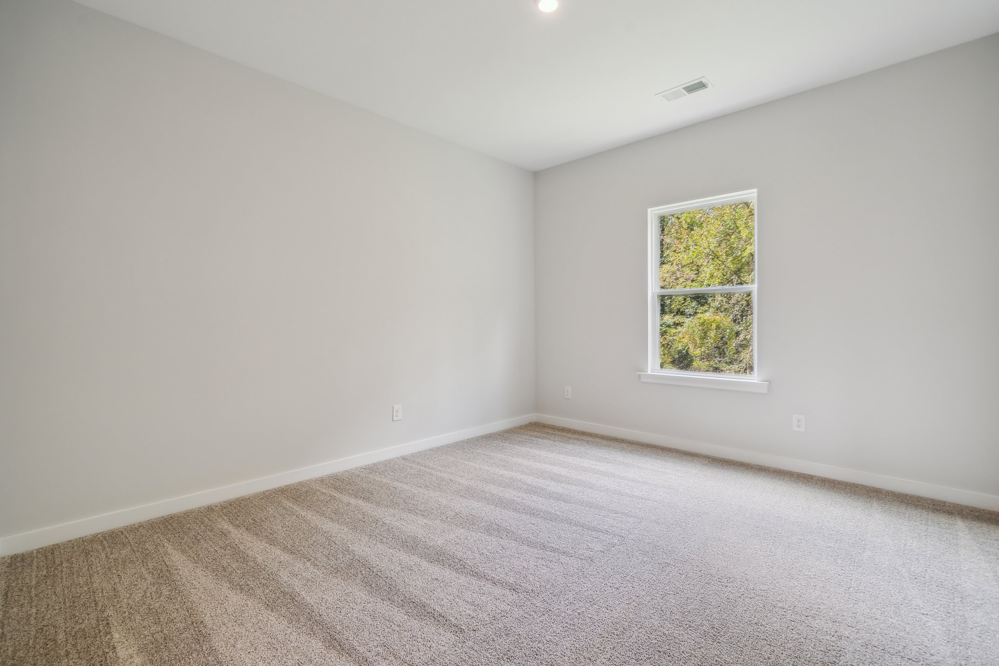 A room with a window and carpet.
