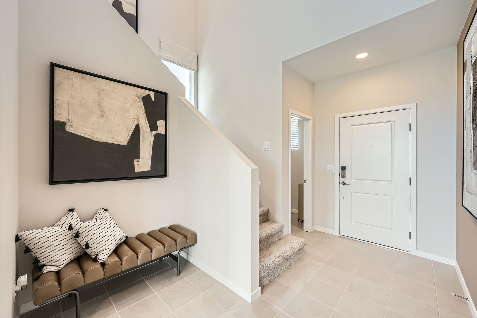 A room with a couch and a painting on the wall.