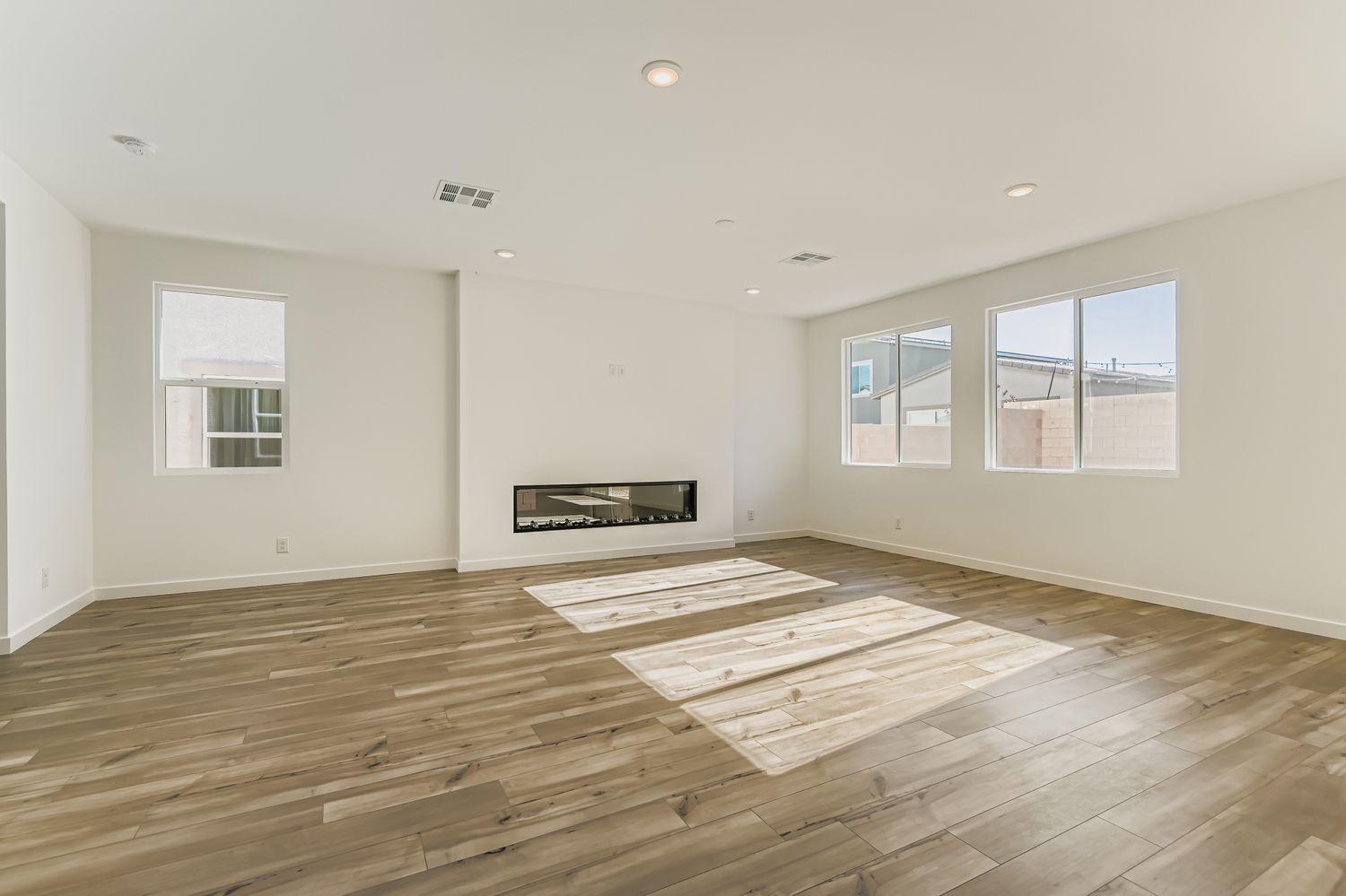 A room with a wood floor and windows.