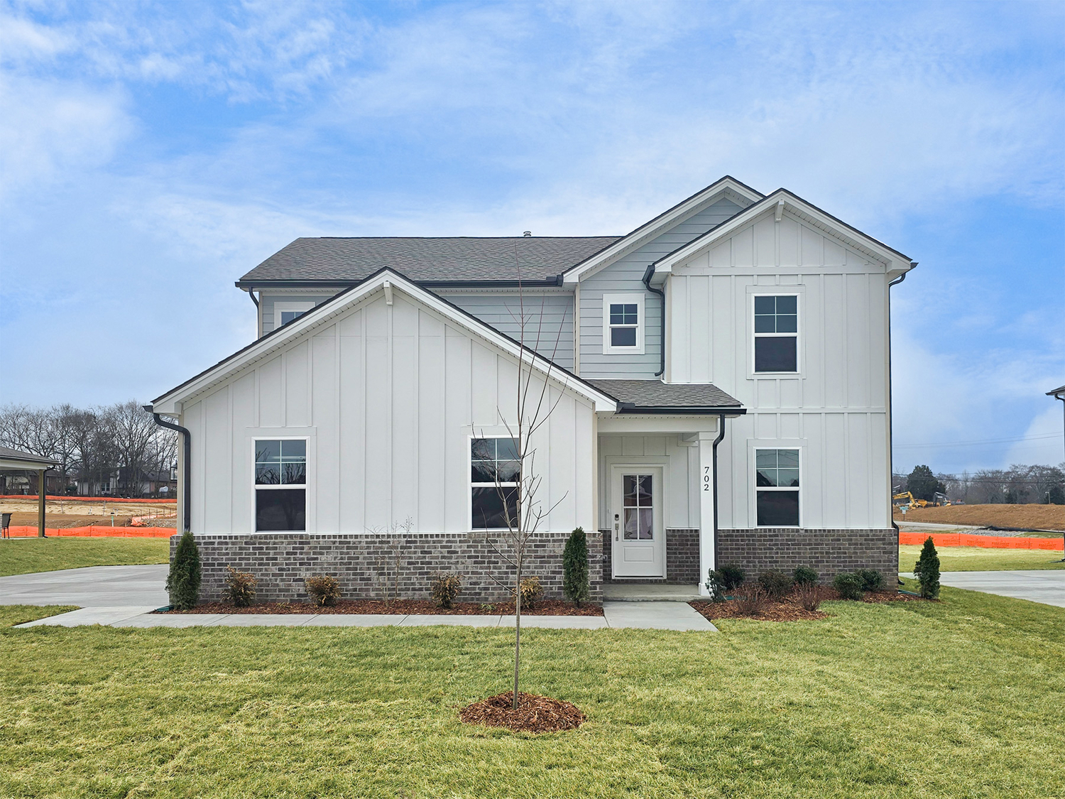 A white house with a lawn.
