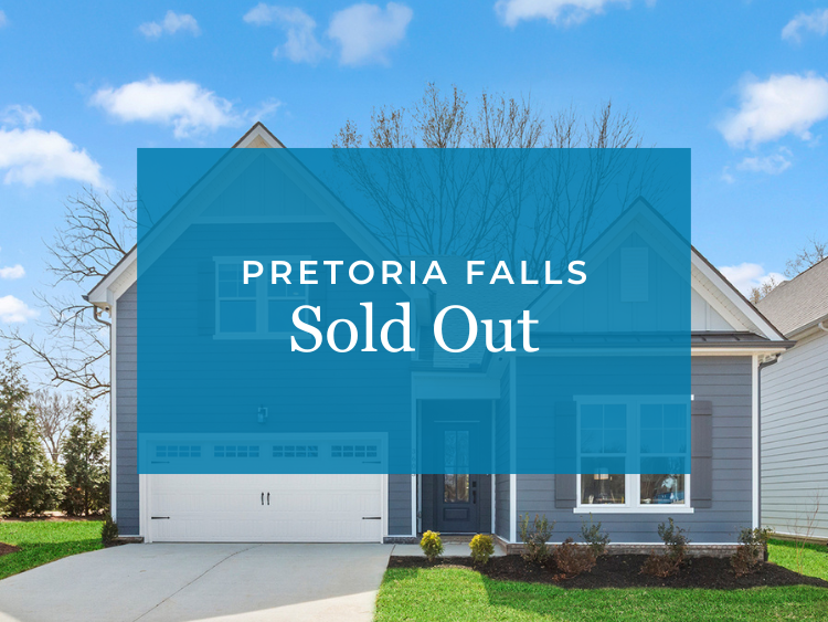 A blue building with a tree in the front.