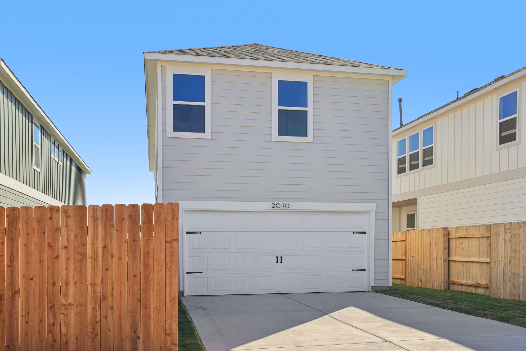 A white garage with a fence.