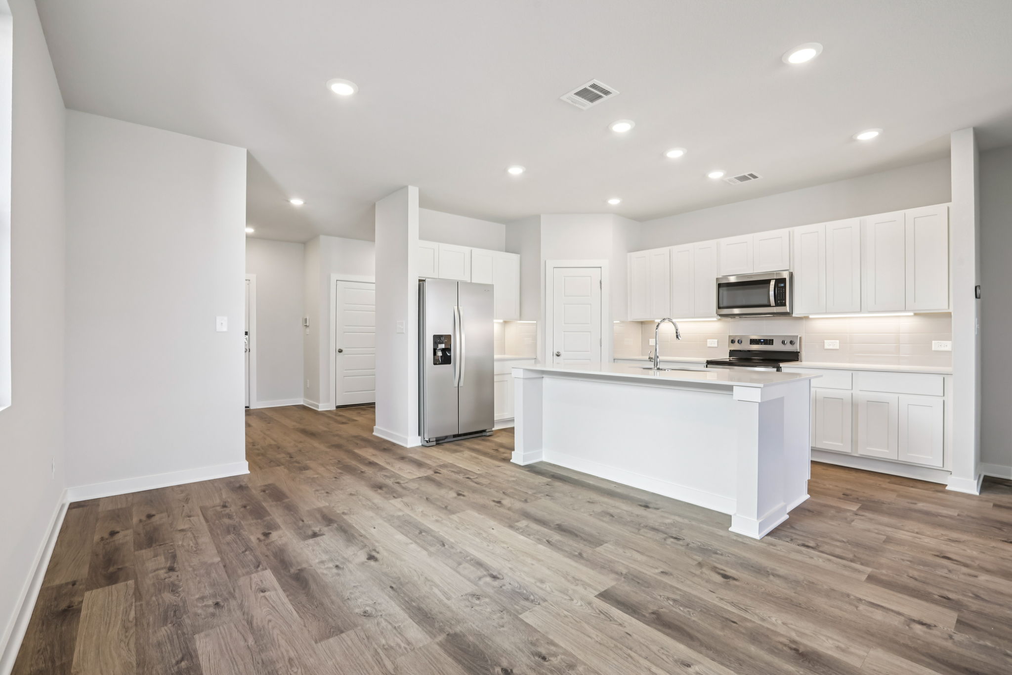 A kitchen with white cabinets.