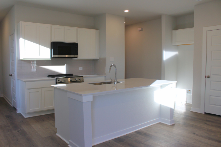 A kitchen with white cabinets.