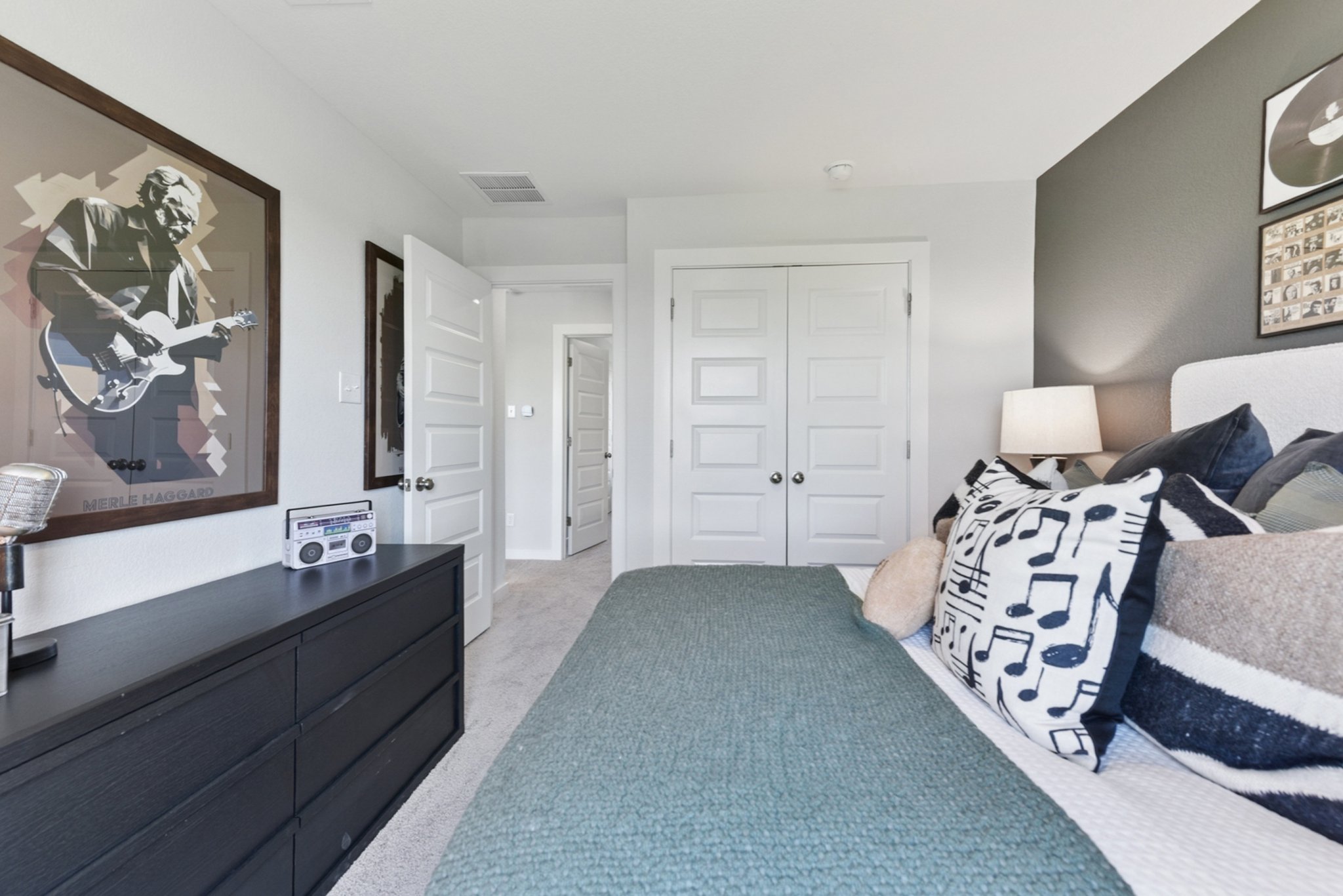 A bedroom with a bed and a dresser.