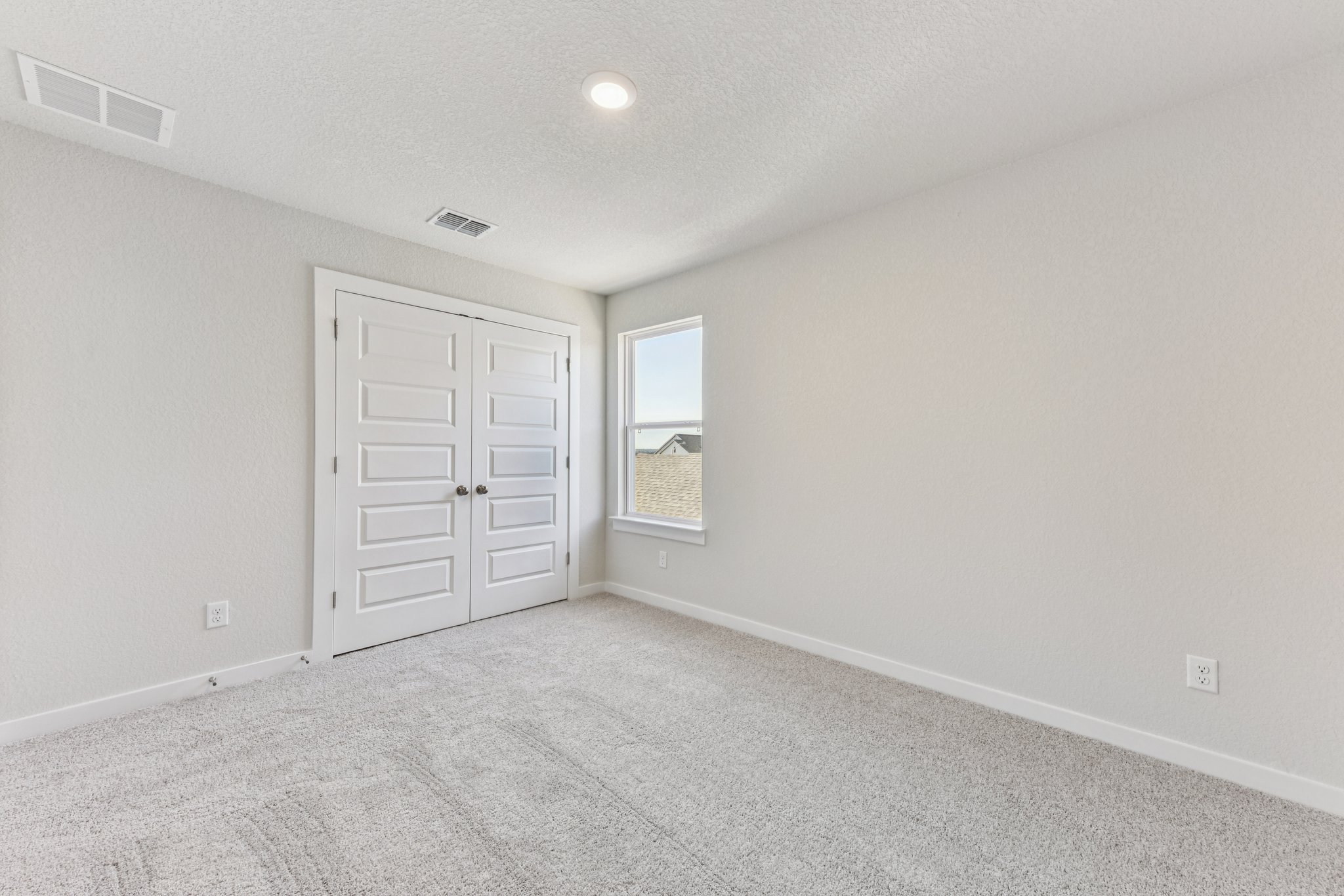 A room with white walls and a window.
