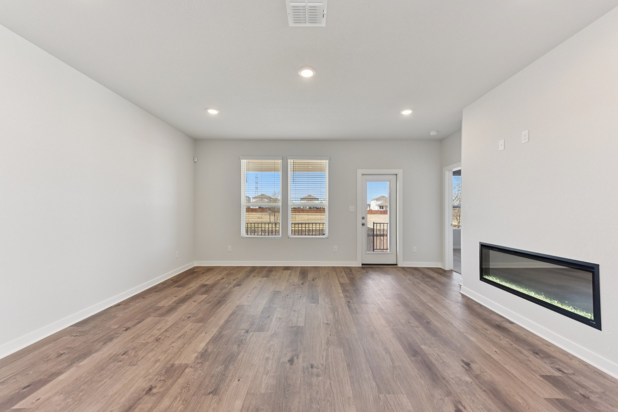 A room with a wood floor and a wood floor with a fireplace.