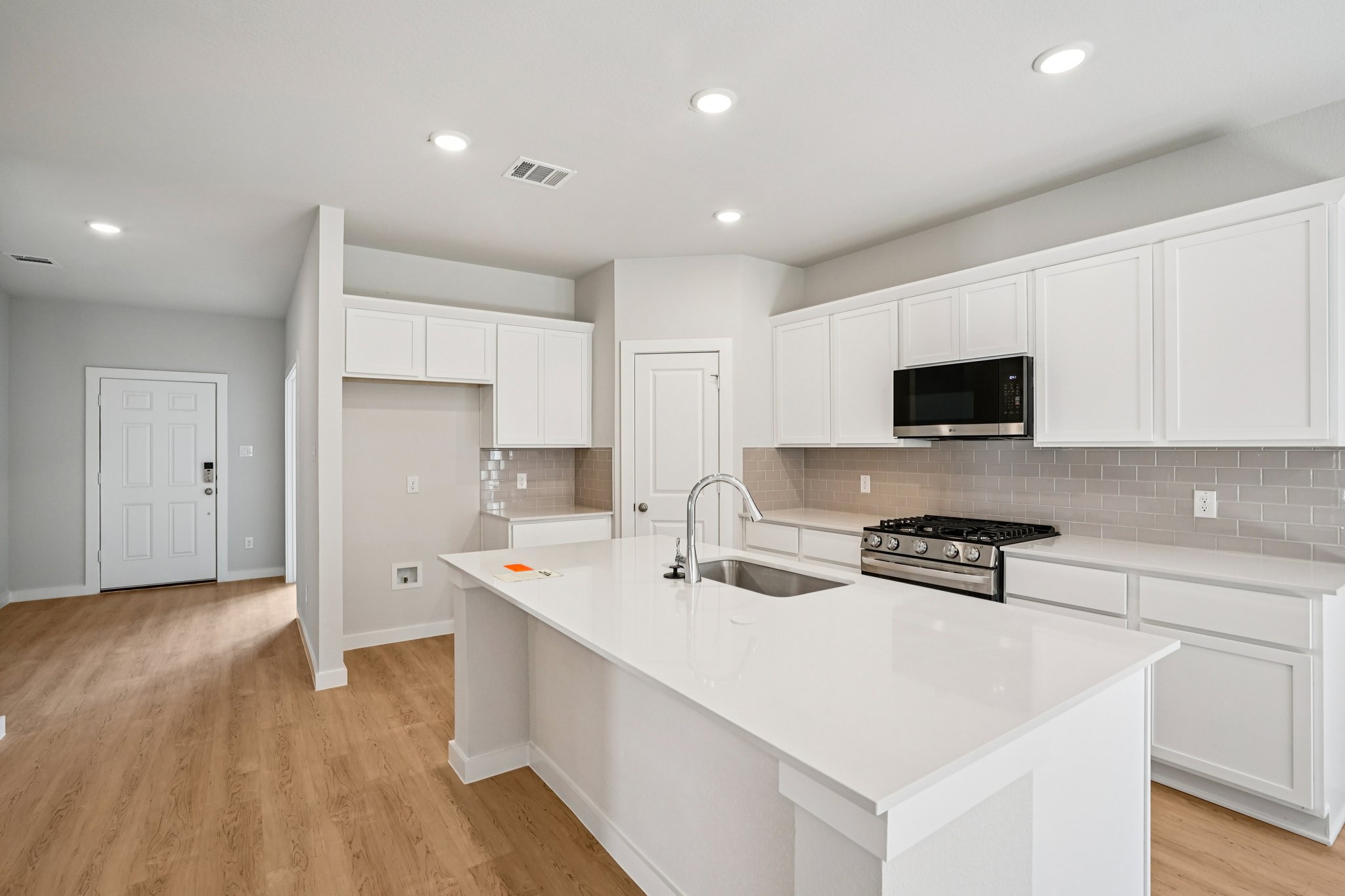 A kitchen with white cabinets.
