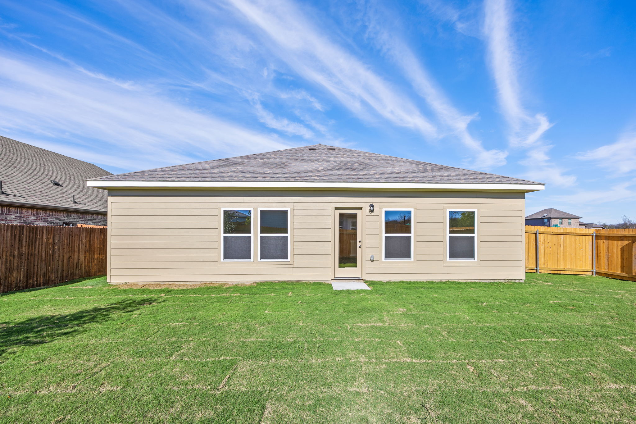 A house with a fence and grass.