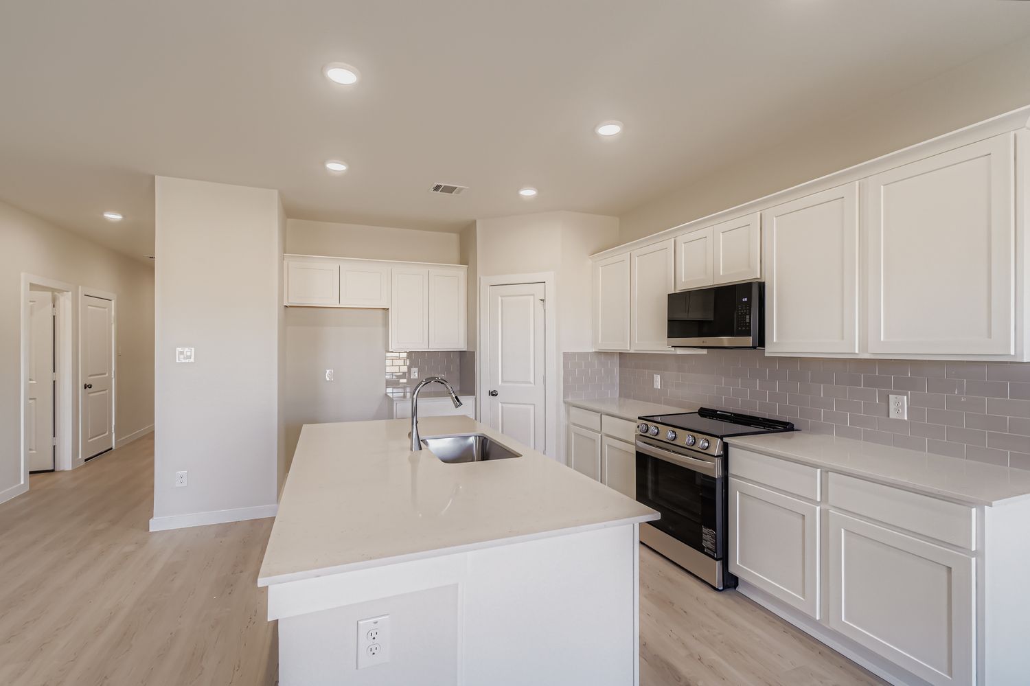 A kitchen with white cabinets.